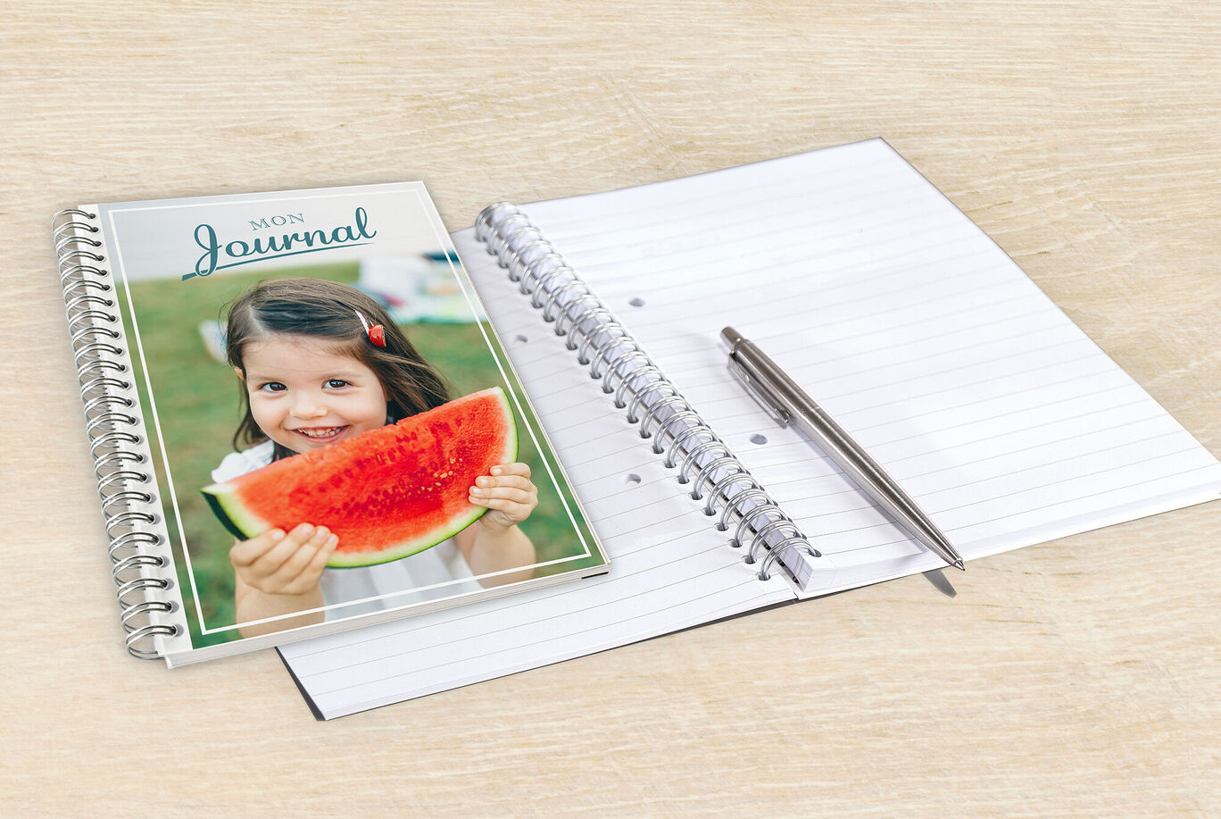 Un carnet ouvert et un crayon à côté d'un morceau de pastèque coloré.