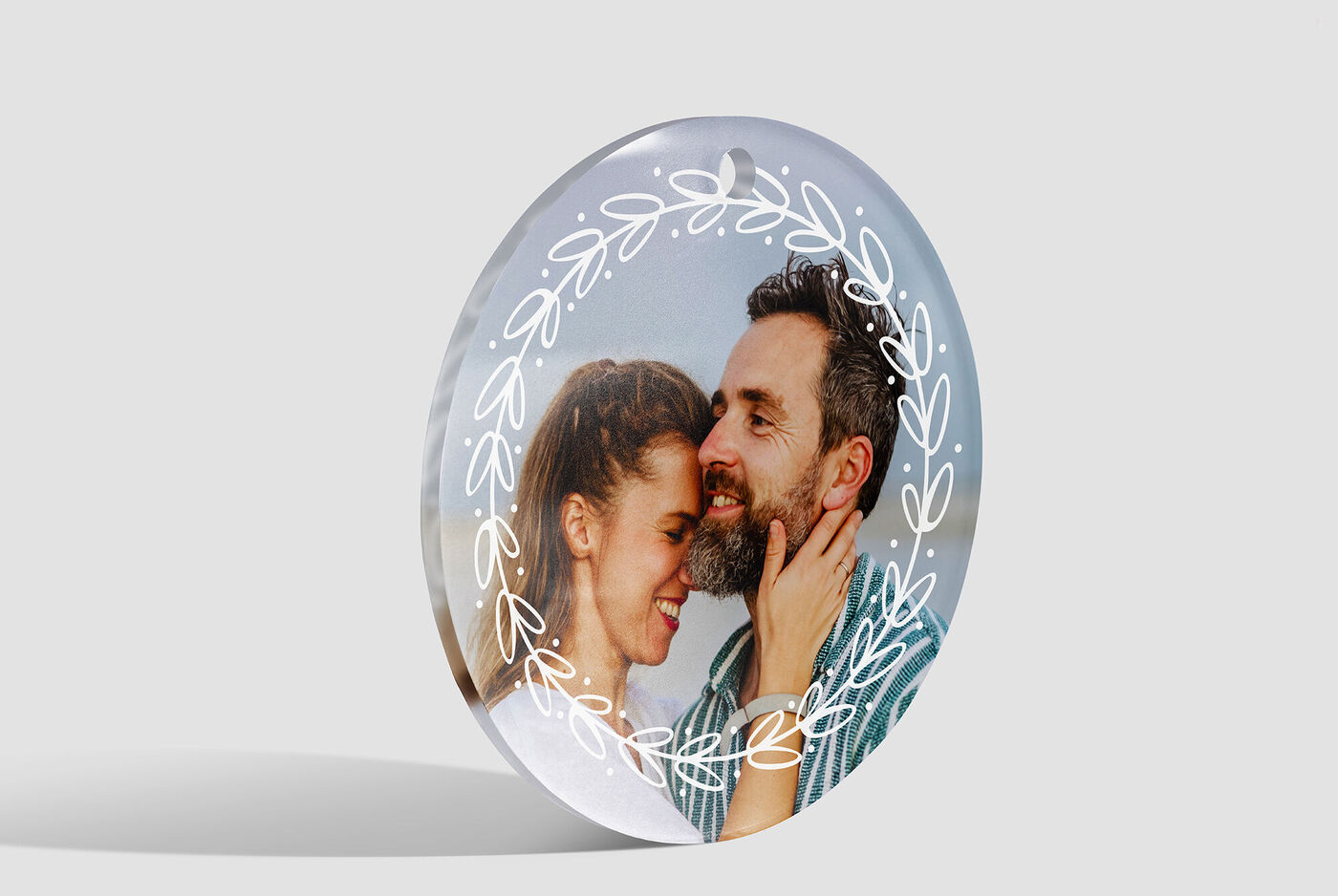 Un cadeau personnalisé en forme de plaque photo brillante avec deux personnes au premier plan montrant une connexion affectueuse. La scène transmet joie et chaleur.