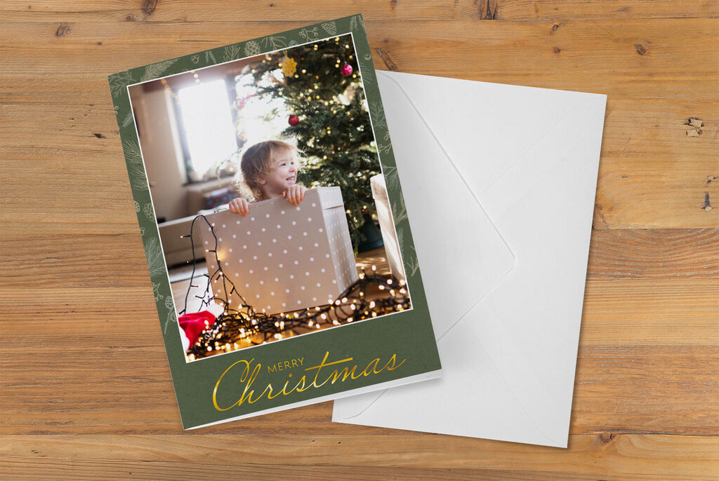 Un enfant joyeux avec un cadeau devant un sapin de Noël décoré