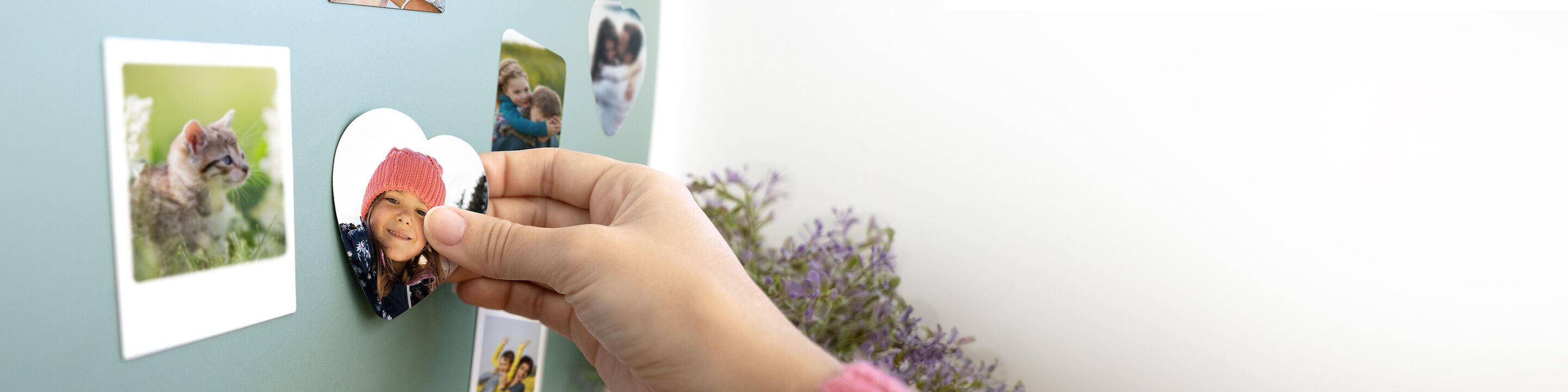 Une main retire un motif en cœur d'un tableau magnétique.