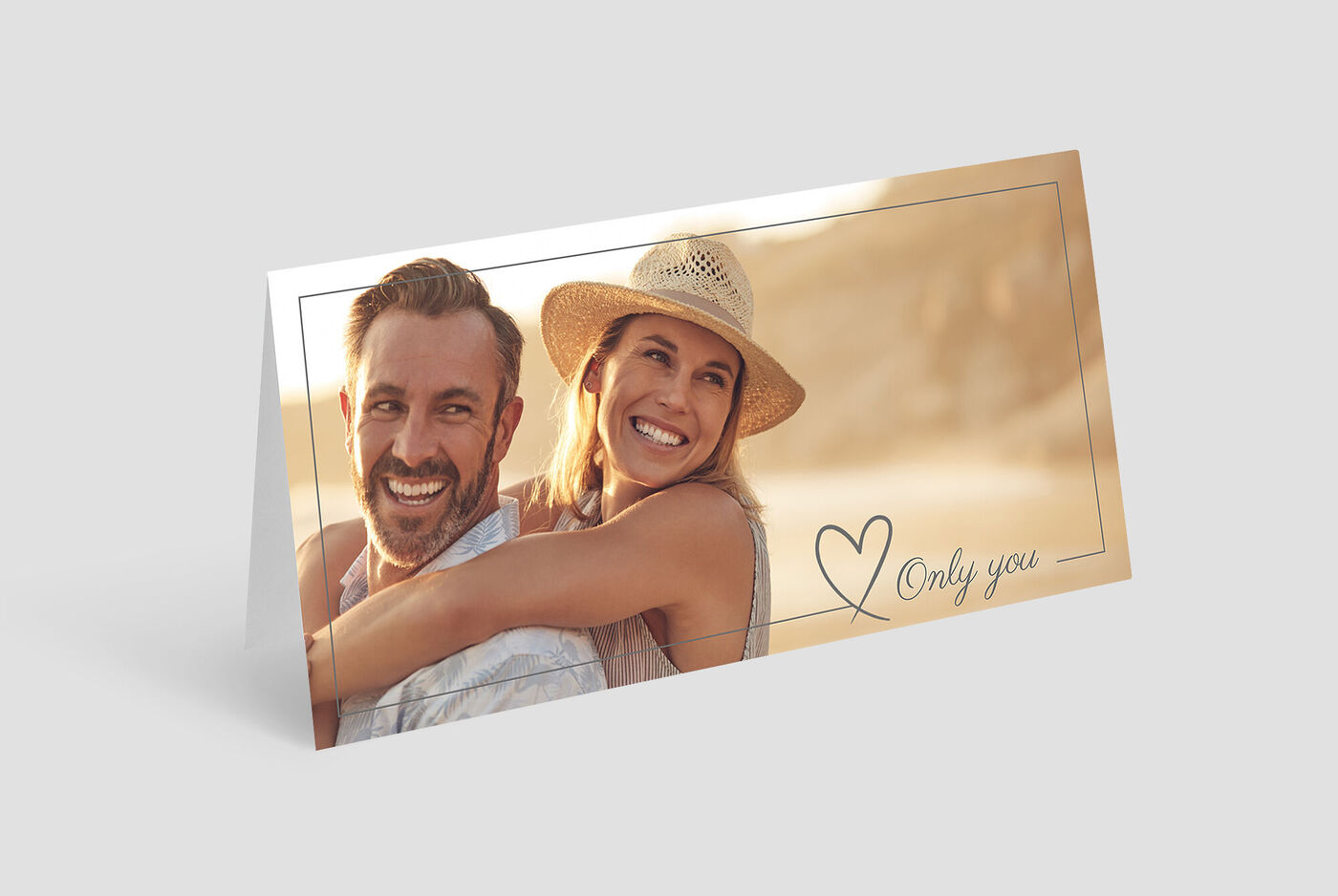 Deux personnes à l’extérieur dans une étreinte amicale, avec un chapeau de soleil, fond de plage.