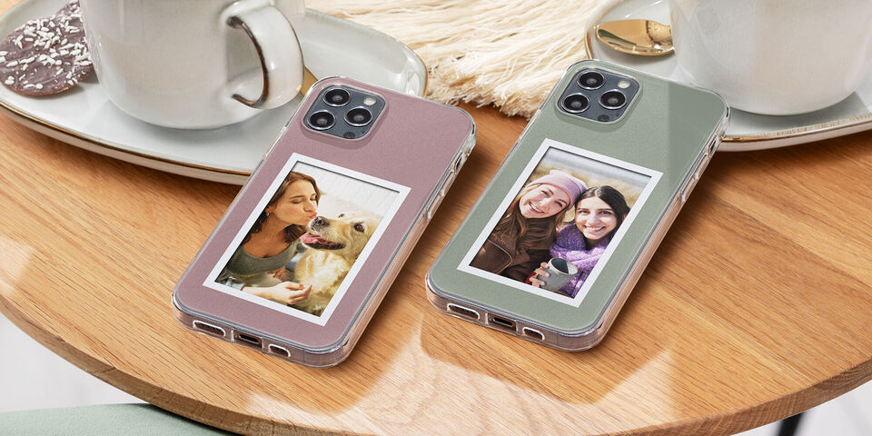 Deux coques de téléphone avec des photos personnelles sur une table en bois à côté des tasses.