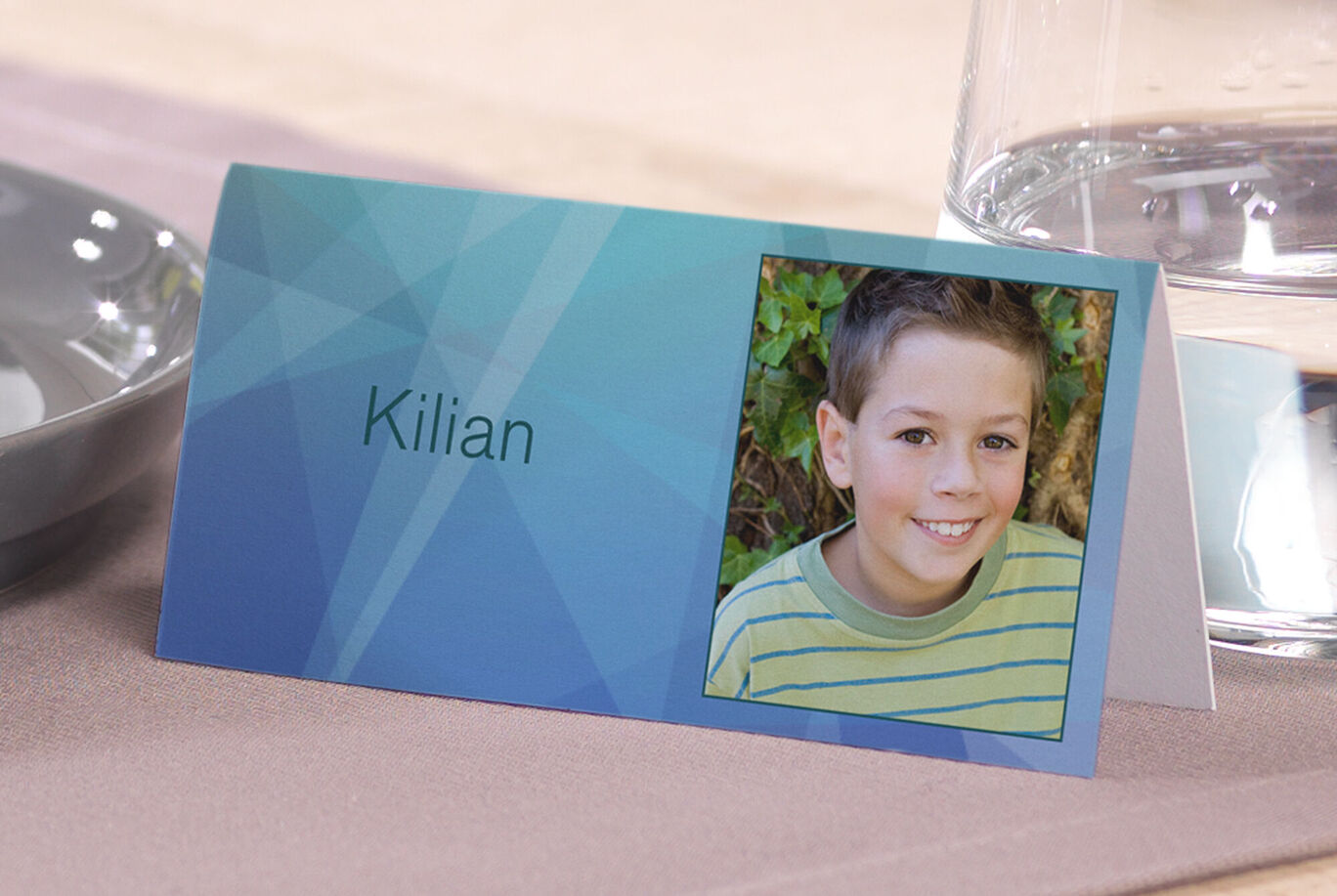 Carte de table avec le nom Kilian sur fond géométrique bleu.