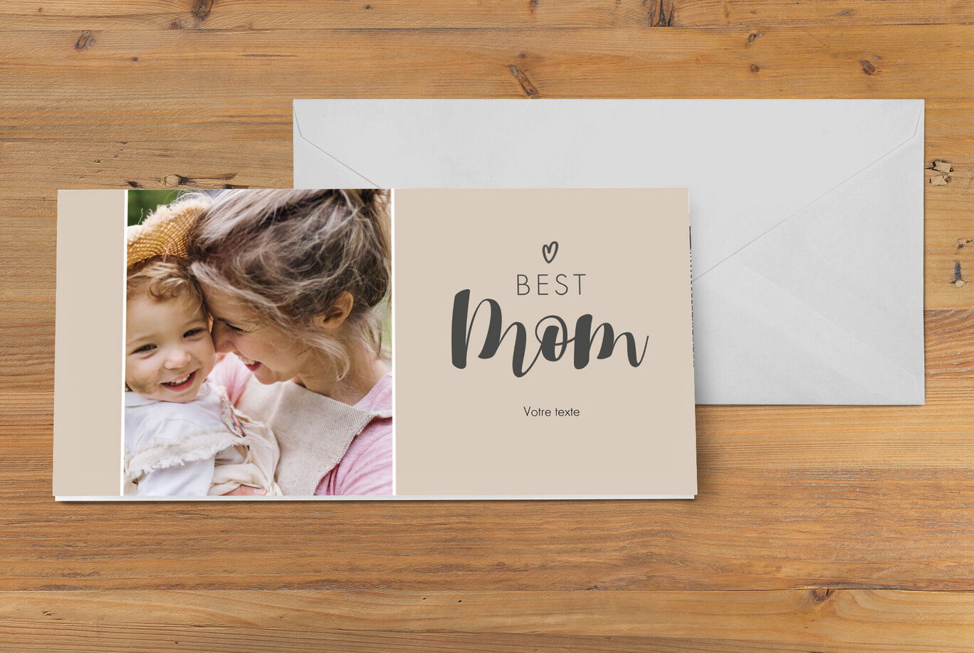 Un livre photo affectueux pour la meilleure maman, intitulé 'MEILLEURE MAM'. Il est sur une table en bois à côté d'une enveloppe.