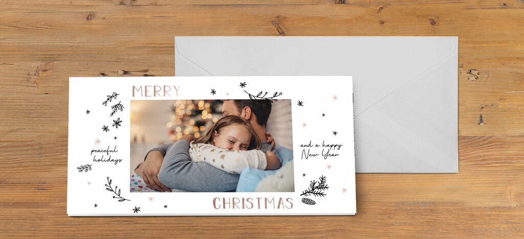 Une carte de vœux de Noël avec le texte 'Joyeux Noël' et une belle illustration autour de l'image. Un sapin brille en arrière-plan.