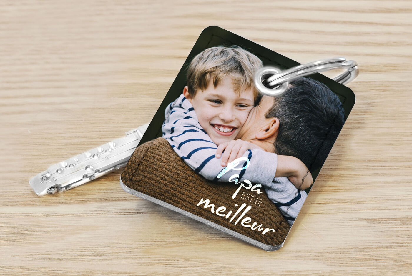 Un moment chaleureux entre un enfant et un adulte s'embrassant. Magnifique porte-clés personnalisé 'Papa est le meilleur'.