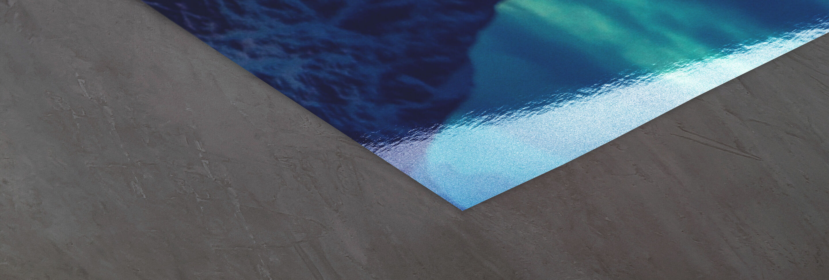 Une surface grise se fond dans une surface d'eau bleue en bas