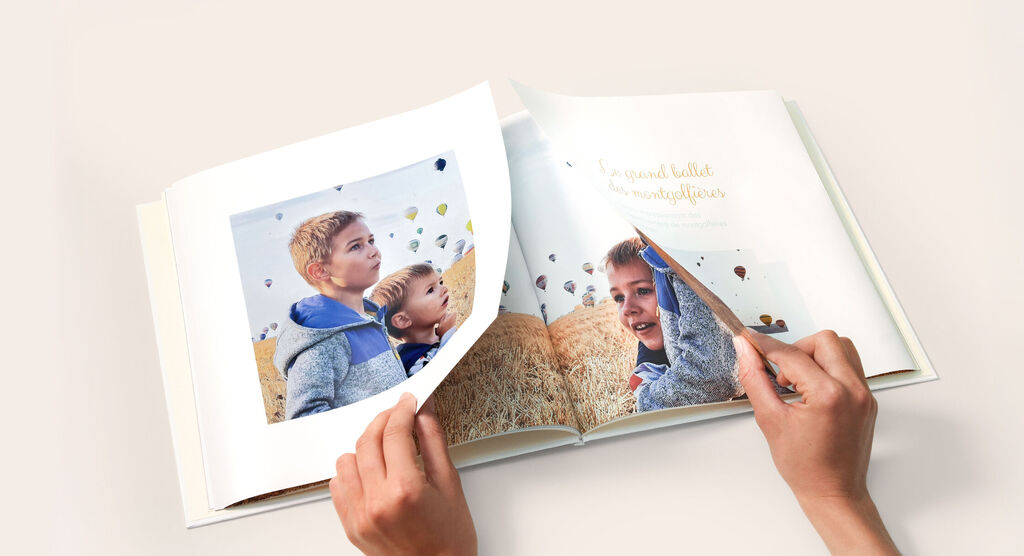 Un livre photo ouvert avec des souvenirs en milieu rural, ballons dans le ciel.