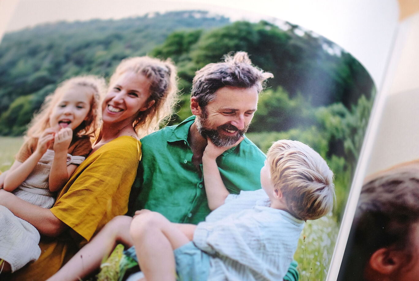 Famille à l'extérieur sur une pelouse, avec des enfants dans les bras.