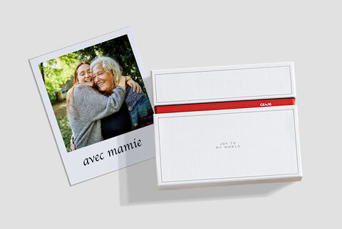 Une belle photo de deux personnes s'enlaçant. Une jolie carte photo et une enveloppe cadeau sont à côté.