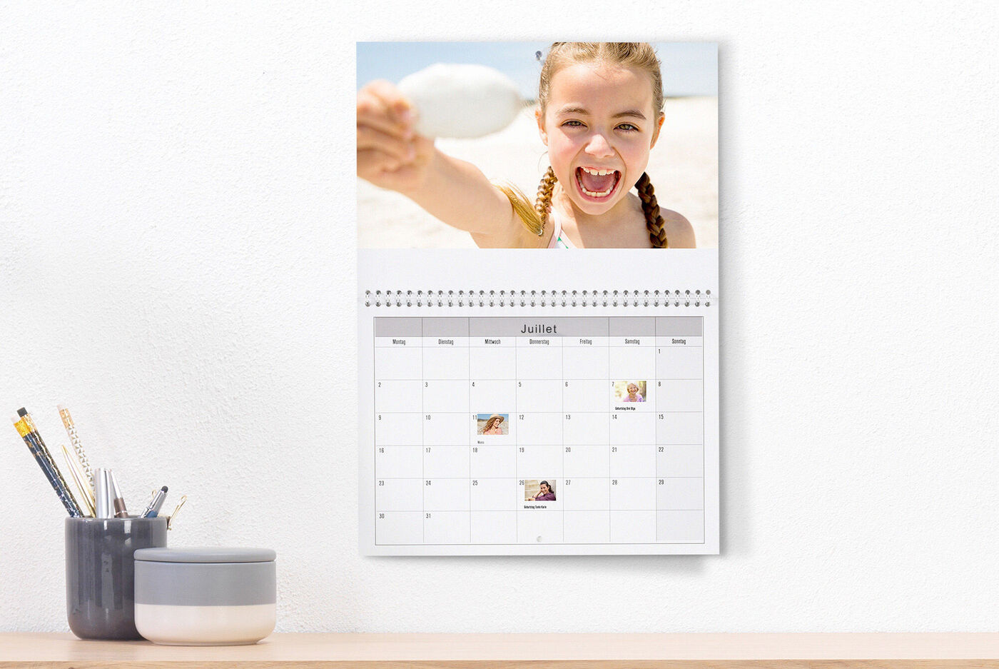 Un beau calendrier photo avec une image d'été et des illustrations colorées. Un enfant joyeux montre quelque chose.