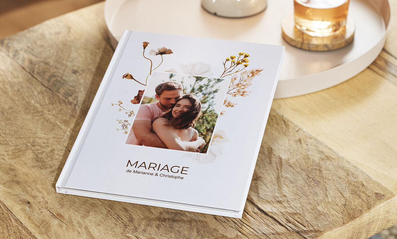 Un livre photo CEWE stylé avec un design floral et une belle photo de mariage.