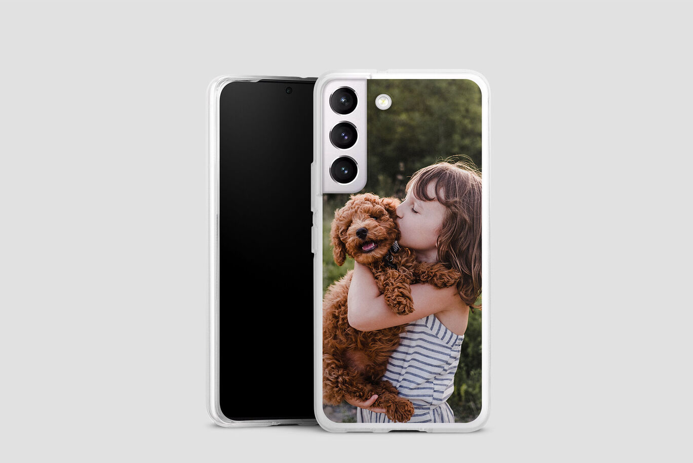 Un enfant tient un chien dans ses bras.