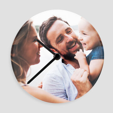 Une famille joyeuse utilisant une horloge créative pour se souvenir de beaux moments.