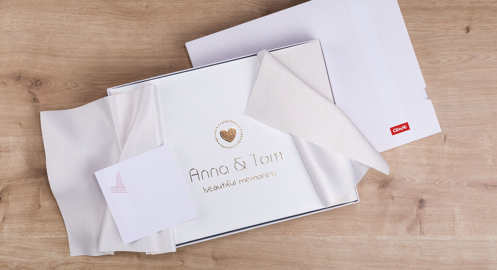 Magnifique album photo CEWE dans une boîte cadeau avec des souvenirs affectueux et des détails personnels.