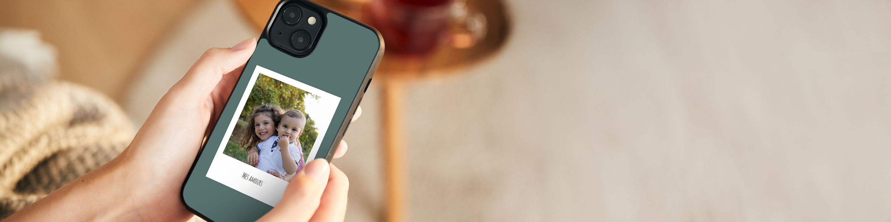 Une personne tenant un smartphone avec une photo de deux amies souriantes.