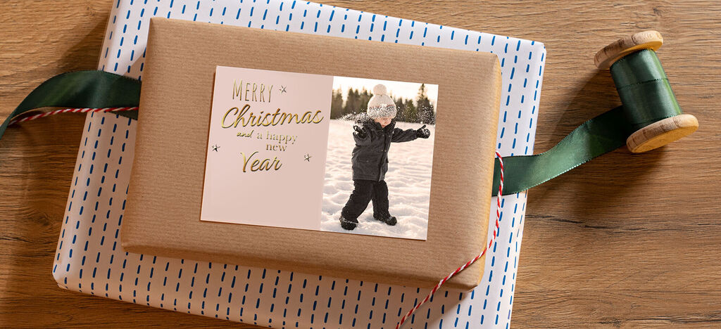Un cadeau de Noël joyeusement emballé avec un enfant dans la neige.