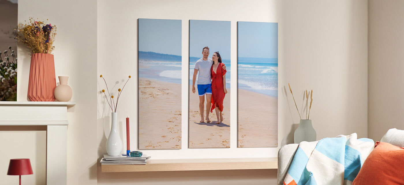 Un couple se tenant sur la plage, souriant et profitant du soleil.