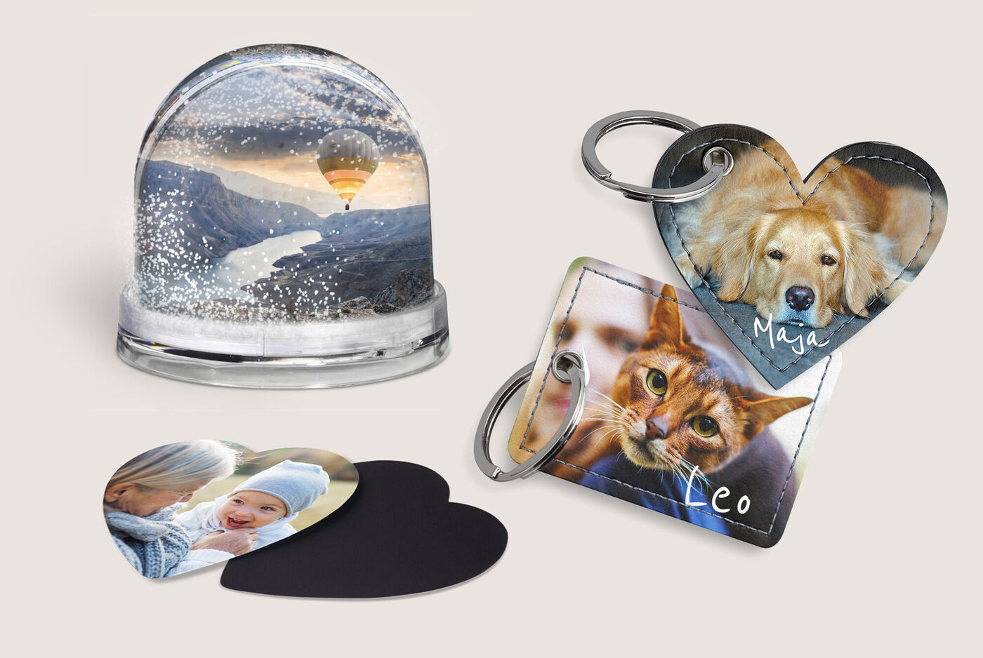 Deux porte-clés personnalisés et un motif de boule à neige avec un paysage montagneux et un ballon à air chaud