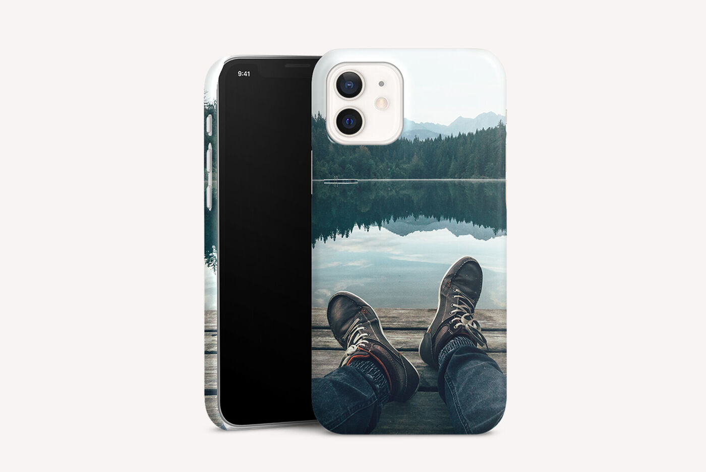 Une personne assise au bord d'un lac calme contemplant le paysage montagneux