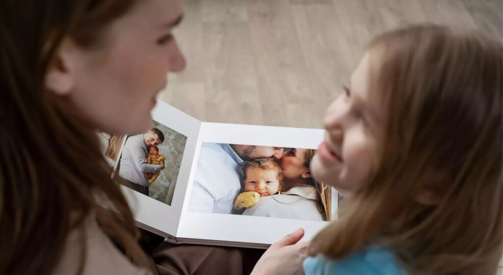Deux personnes regardent tendrement un album photo souvenir.