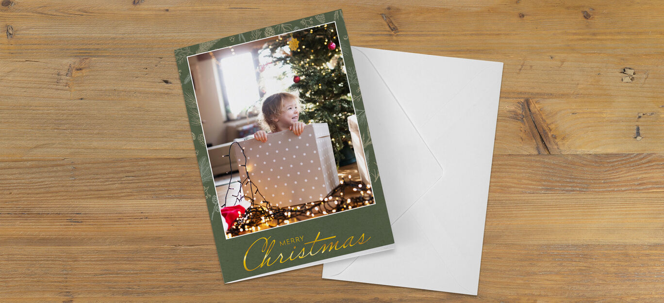 Un enfant entouré de décorations de Noël ouvrant un cadeau sous un arbre festif