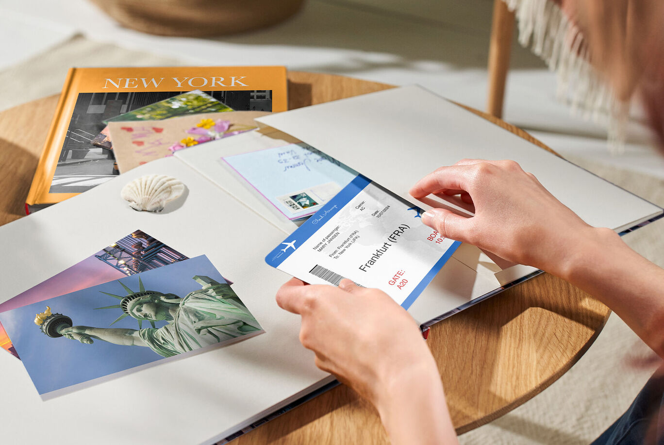 Une personne regarde un album photo ouvert et tient un billet d'avion, entourée de souvenirs de vacances.