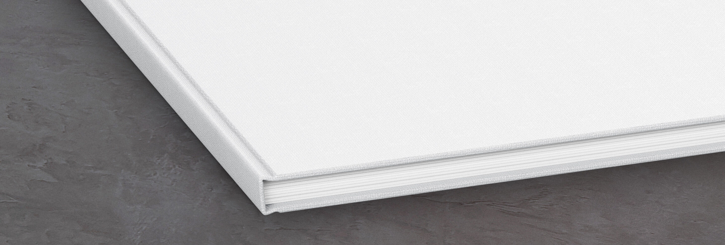 Un livre photo carré et vide sur un fond sombre.