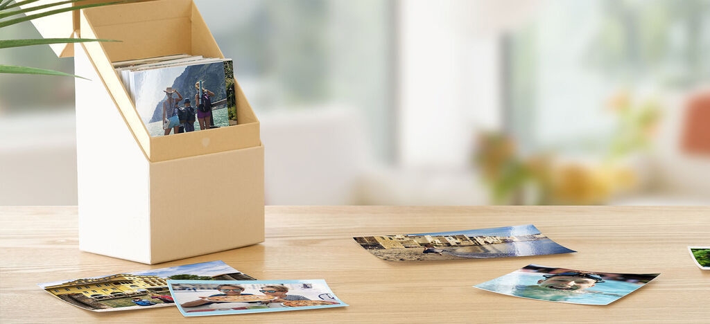 Un élégant conteneur de photos avec plusieurs photos entourant sur une table.