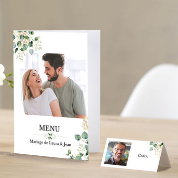Menu élégant pour un mariage avec des éléments floraux et des panneaux de nom personnalisés.