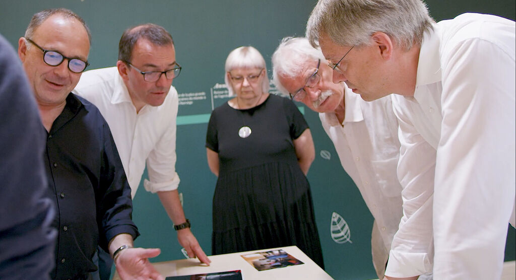 Des gens regardent ensemble un Fotobuch à table