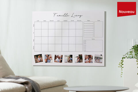 Un texte mural avec un calendrier familial et des images, accroché au mur