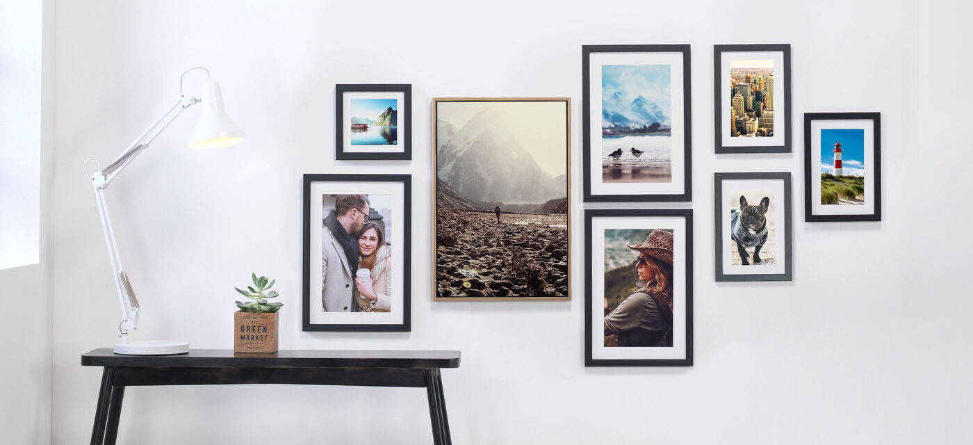 Mur avec diverses photos encadrées et une lampe