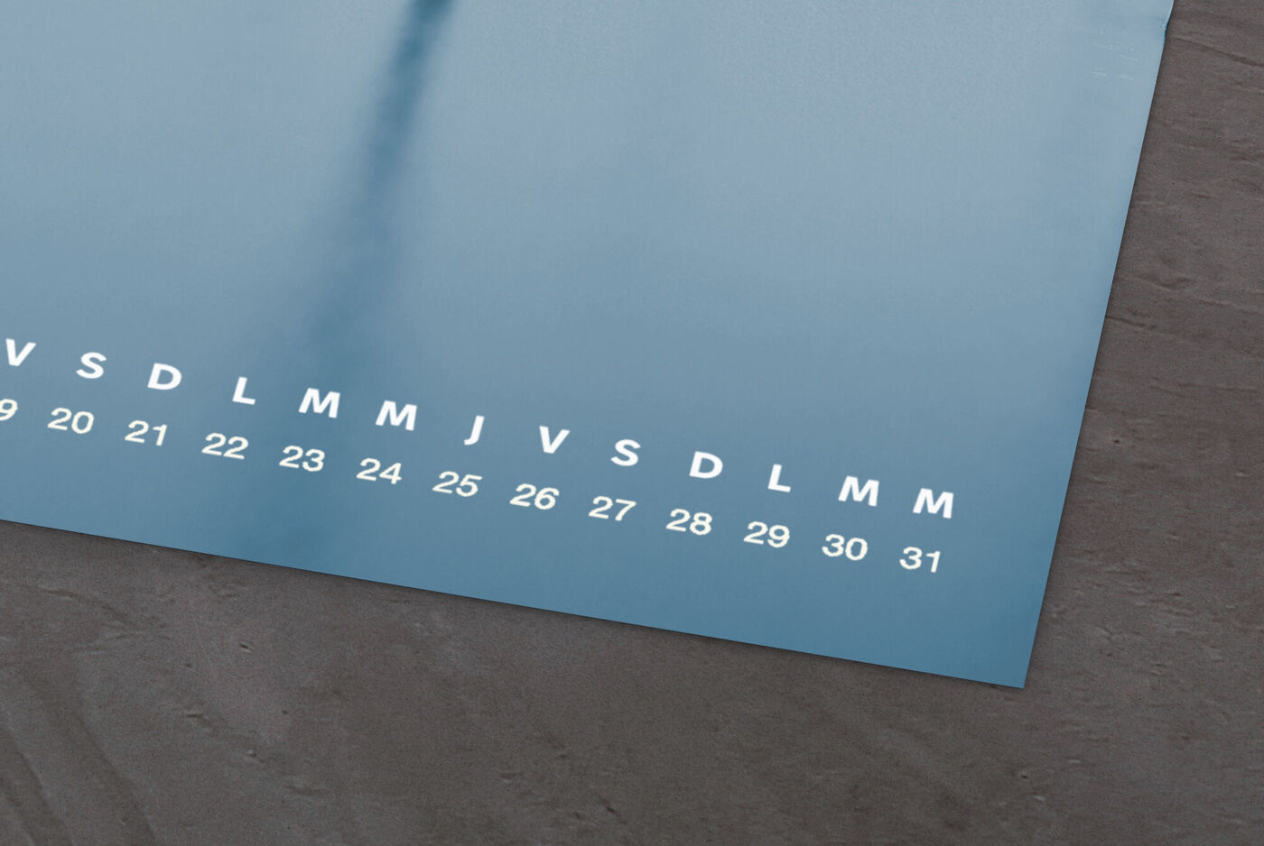 Journée de calendrier mensuel avec un fond bleu et des chiffres blancs sur une table rustique.