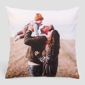 Un couple heureux soulève un enfant dans les airs, partageant de la joie dans la nature