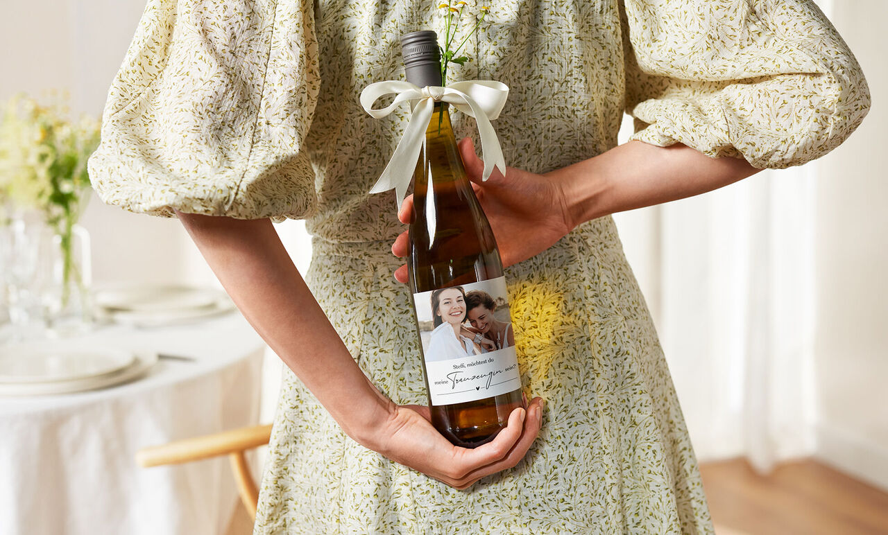 Femme tenant une bouteille personnalisée avec une photo et un message d’anniversaire
