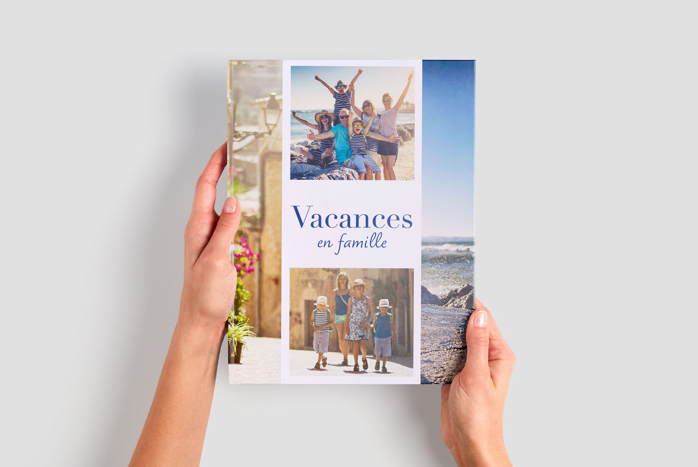 Une main tient un album photo CEWE avec des photos d'une famille en vacances.
