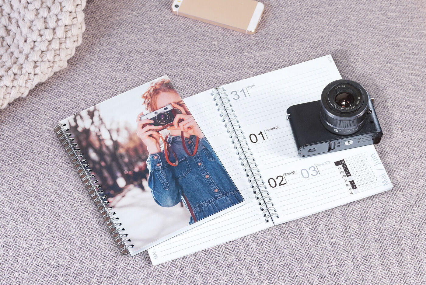 Un carnet ouvert avec une photo sur la couverture et un appareil photo à côté.