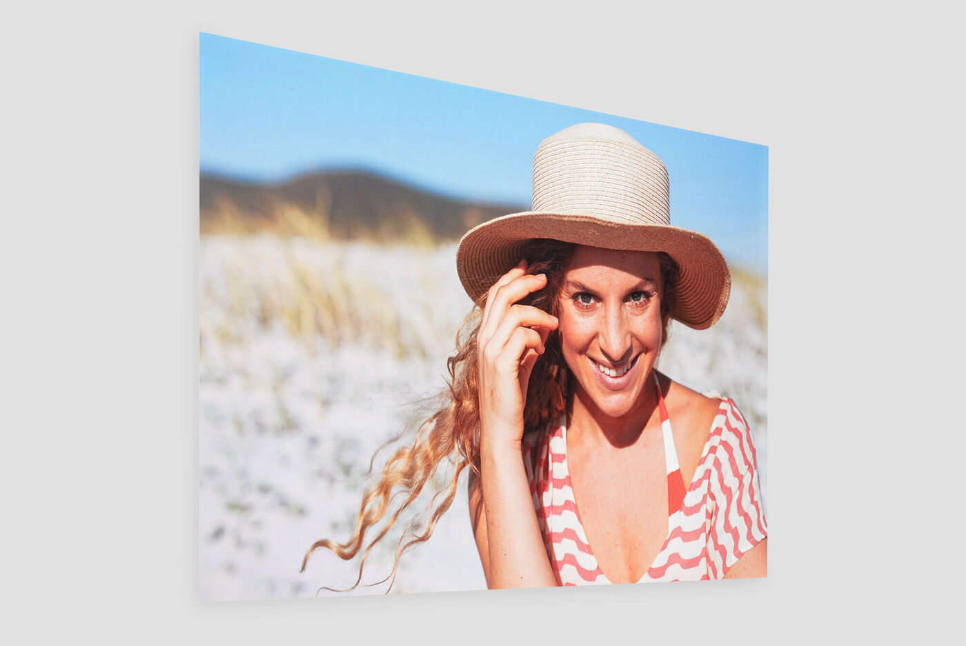 Une femme avec un chapeau de soleil profite de la plage.