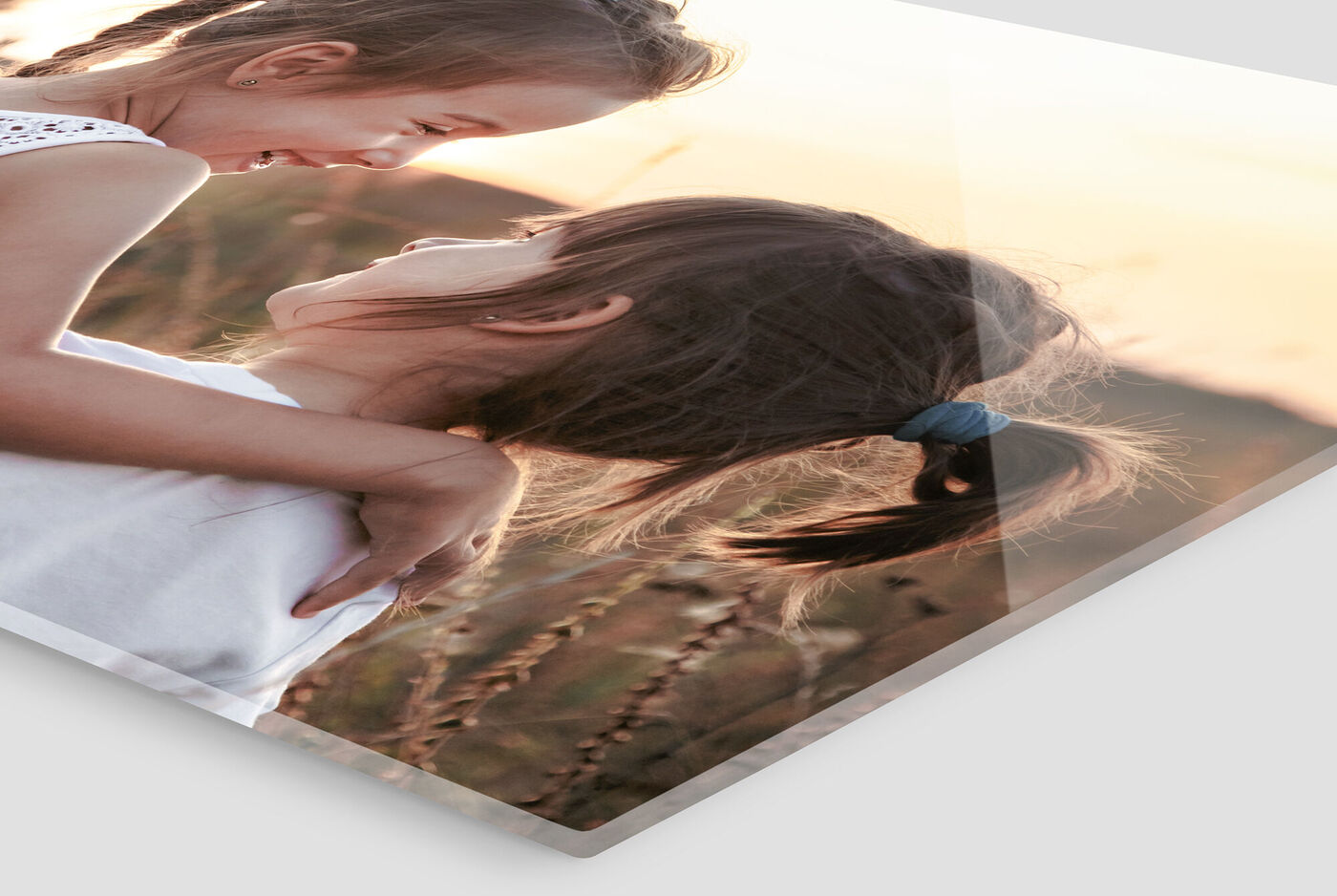 Deux filles sont dans un champ et se sourient pendant le coucher du soleil