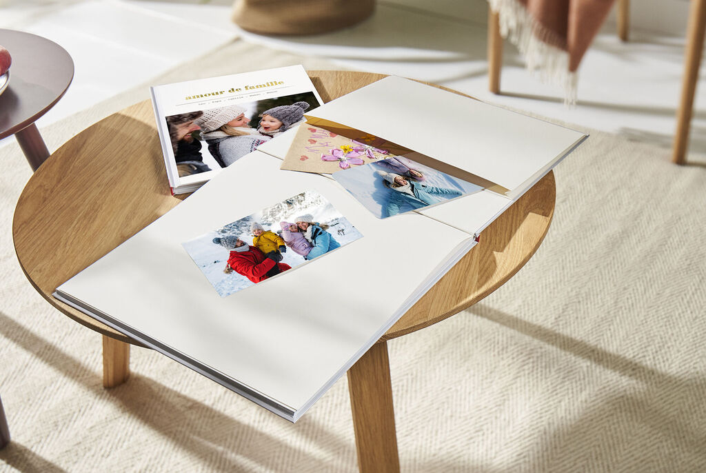 CEWE album photo ouvert avec des photos de famille sur une table